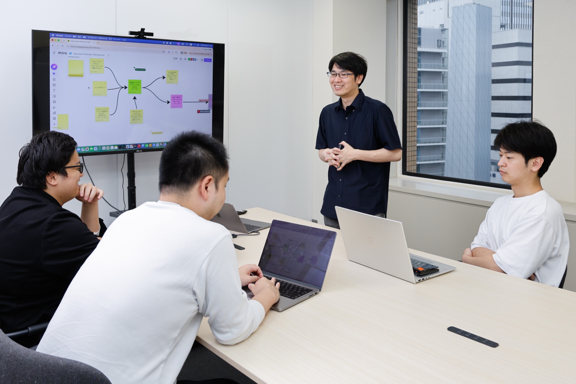 ホワイトボードを囲んで振り返りを行うテイラーのメンバー